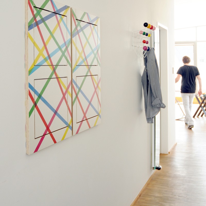 Fläpps Klappstuhl bedruckt, zusammengeklappt an der Wand wie ein Bild